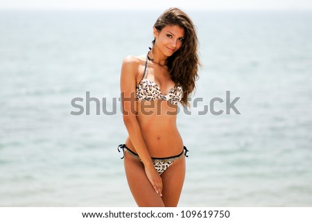 Portrait of a woman with beautiful body on a tropical beach, wearing a bikini