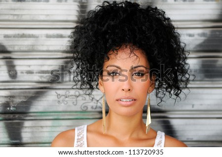 Portrait of a young black woman, model of fashion in urban background, with afro hairstyle