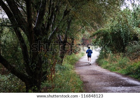 Portrait of a woman runner running in autumn forest