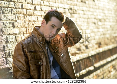 Portrait of handsome man with modern hairstyle in urban background