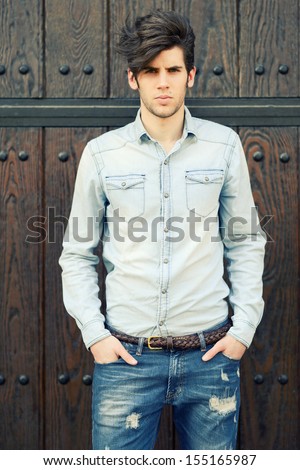 Portrait Of A Young Handsome Man, Model Of Fashion, With Modern Hairstyle In Urban Background