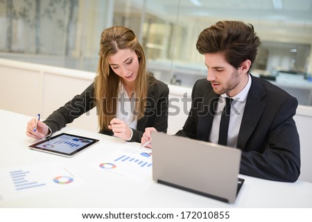 Portrait of business man and woman working around table in modern office