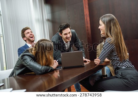 Businesspeople, teamwork. Group of multiethnic people laughing in an informal meeting in an office