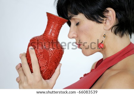 Dark hair woman back with red vase