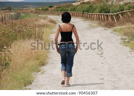 Young woman walking on path in the field