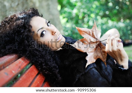 Young black beautiful woman siting on bench in park