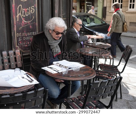 PARIS â?? APRIL 12: An unidentified man enjoys the spring weather in Paris and reads at a street-side cafe on April 12, 2012.