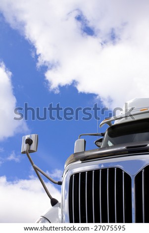 Transport truck against sky with clouds