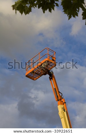 Mobile crane arm and basket against dramatic sky