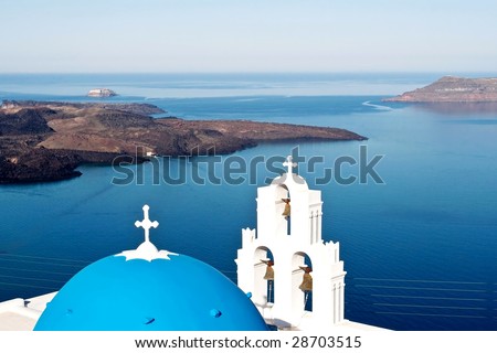Overview of blue Aegean ocean and volcanic island over a blue dome church in Santorini, the most beautiful and romantic Greek island.