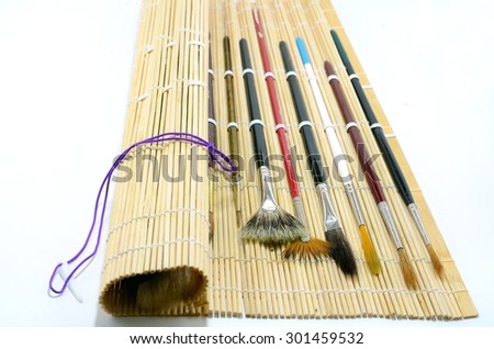 Watercolor brushes in the bamboo brush holder isolated with white background