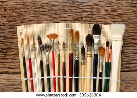 Watercolor brushes with natural bamboo brush holder on wood
