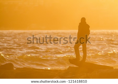 Man stand on a rock in the back light