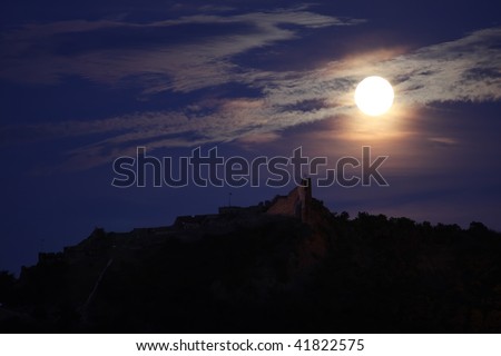 A full moon is above a castle