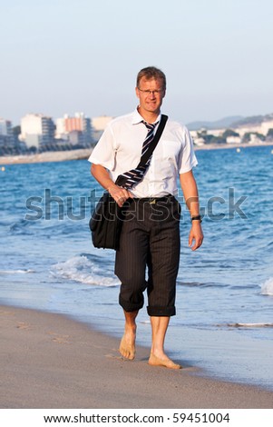 Blond , young businessman walks close to the sea