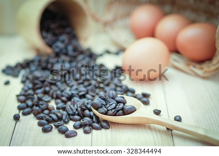 coffee bean and egg on the wood floor, select focus point coffee on wooden spoon