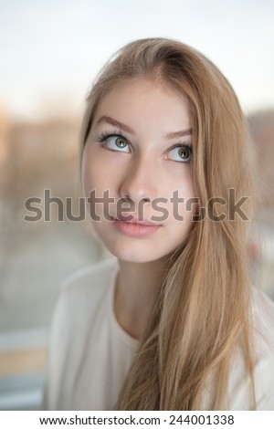 Close up portrait of an attractive teen girl. She is rolling her eyes up and looking.