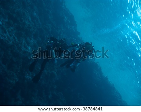 Two techno divers drift under the ocean surface in Blue Hole, Dahab, Egypt