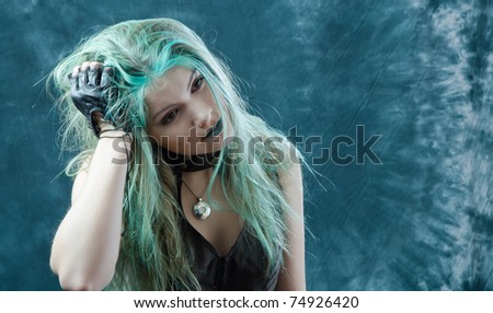 Photo session of the pretty young blonde girl with green hair in the steampunk style