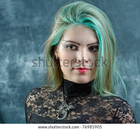 Studio portrait of young provocative goth girl with green hair