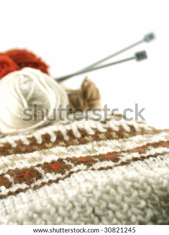 A sweater with wool and knitting needles isolated