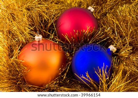 A few colorfull christmas ornament decoration ball, over gold chain