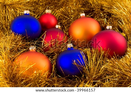 A few colorfull christmas ornament decoration ball, over gold chain