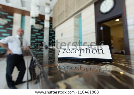 Hotel reception desk with a table and receptionists on a background
