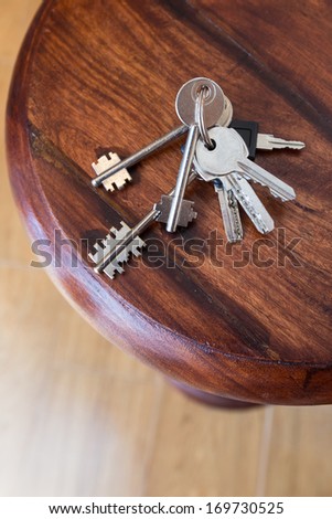 Bunch of keys lying on a wood shelf at the entrance