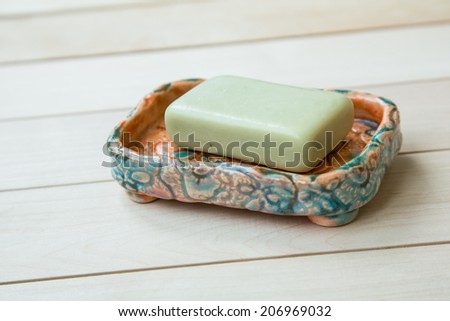 slightly used bar of natural olive soap in a ceramic hand made soap-dish