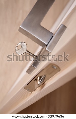 Metal door handle with a key in a keyhole