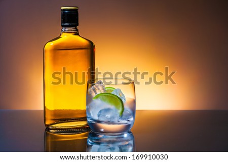 Glass and bottle of hard liquor like scotch, bourbon, whiskey or brandy