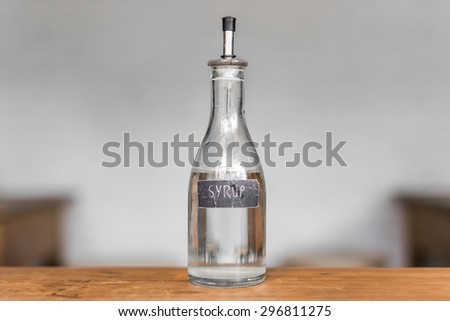 a bottle of syrup on the wooden table