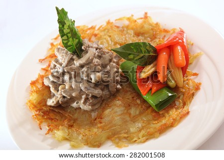 Meat on potato cake with vegetables