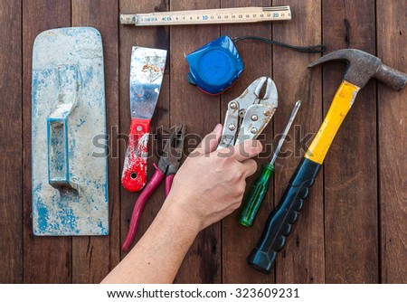 Construction hand tools with hand over wooden floor