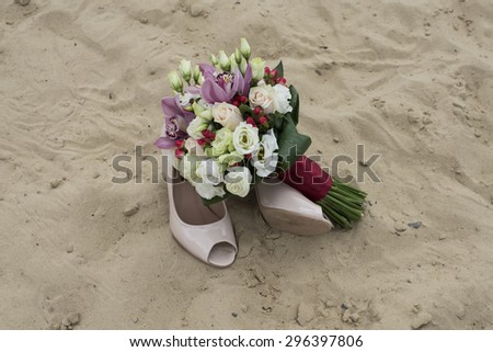 wedding bouquet and shoes in the sand