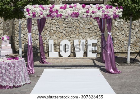 Floral arrangement at a wedding ceremony. 'love' letters