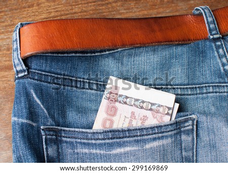 blue jeans with brown leather belt and money in back pocket.