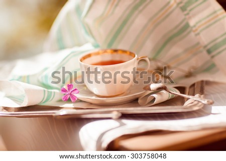 Cup of tea with flowers on table in autumn with fresh flower and towel on table