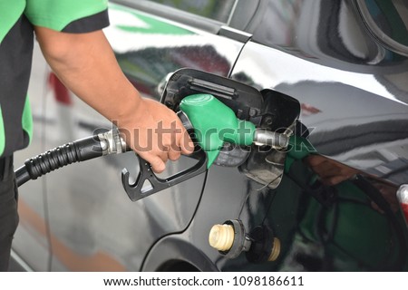 Man hand refuelling the car, Pumping gasoline fuel in car at petrol station.