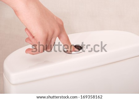 Children hand flushing toilet. Space available on left-hand side for text.