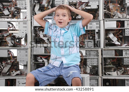 The surprised boy on a background of a wall from old computer case. Horizontal orientation.
