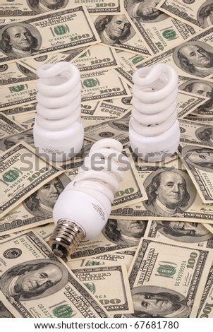 Three luminescent lamps on a background from dollars