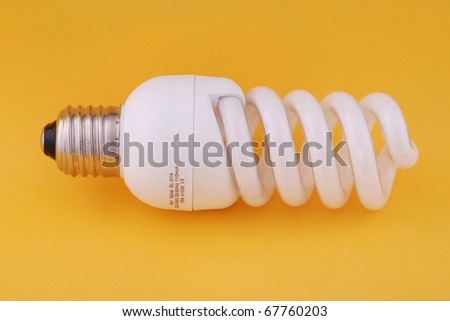 Compact Fluorescent Light Bulb. On yellow backlground.