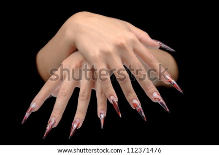 Closeup of hand of young woman long nail-art manicure on nails isolated on black