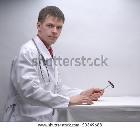 Portrait of young doctor with medical hammer