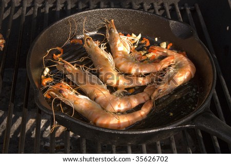 Tiger prawns cooking in griddle on barbecue