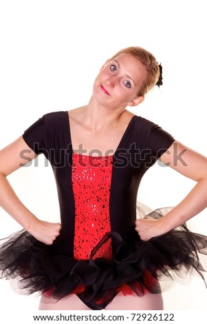 Pretty blonde teenage girl in black and red ballet costume pulling funny face. Photographed against white background