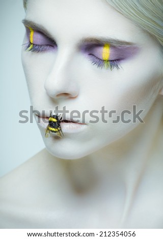 Bumblebee: model with creative make-up and bug on her lips. Large size