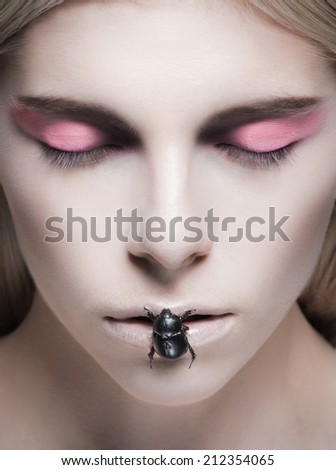 Beauty portrait of model with make-up and bug on her lips. Close-up portrait